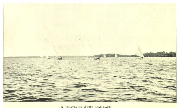 Ein Regatta auf dem Weißen Bärensee mit Booten auf dem Wasser, Bäumen im Hintergrund und Text unten.