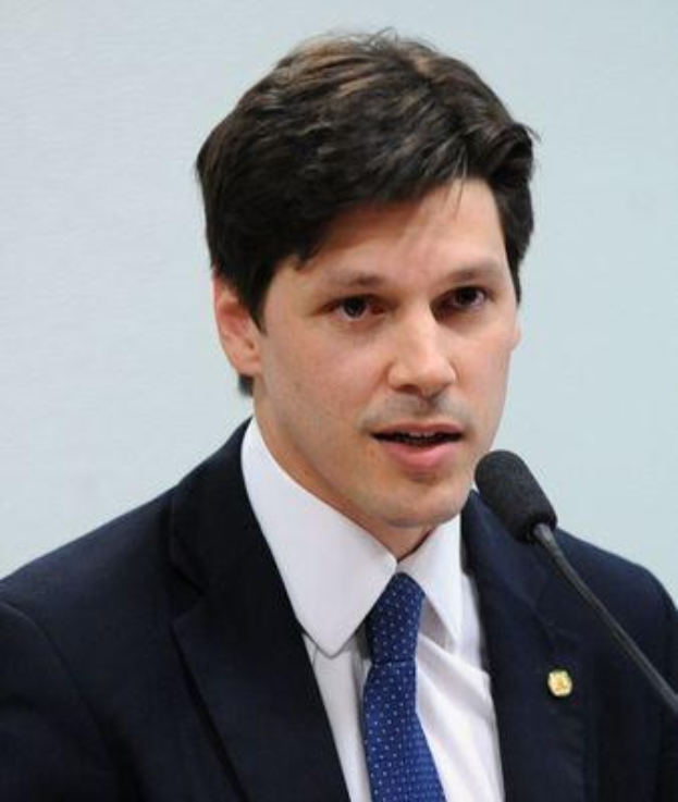 Ein Mann im Anzug und Krawatte spricht in ein Mikrofon an einem Podium, wahrscheinlich zur Genehmigung eines Gesetzes durch die Regierung, das den Internetgebrauch verbietet.