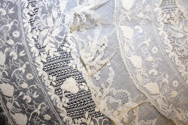 Nahaufnahme eines weißen Hochzeitskleids mit feiner Spitzenverzierung