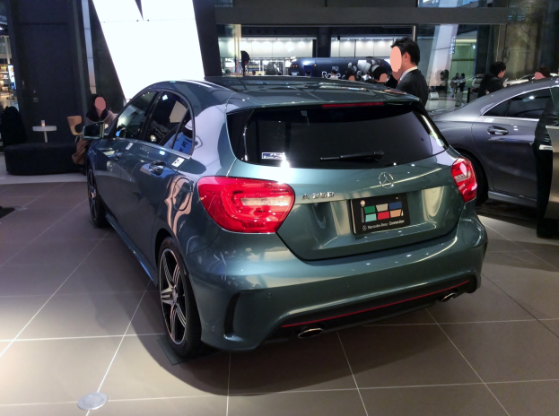 Ein Mercedes-Benz A-Klasse Hatchback auf der IAA in Frankfurt, ein schlankes, modernes Design mit glänzender schwarzer Lackierung und Chromakzenten, umgeben von einer Gruppe von Menschen.