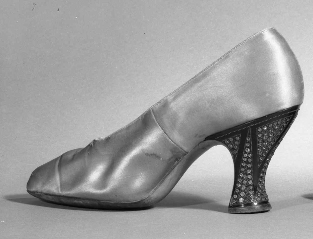 Schwarz-weiß-Foto eines Paares glänzender High Heels aus den 1930er Jahren.