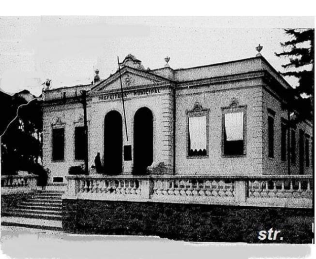 Schwarzes und weißes Foto eines Gebäudes mit Fenstern, Türen, Säulen, Treppen, Geländern, Pflanzen und Bäumen sowie einem Himmel im Hintergrund und einem Text am unteren Rand, der 'Prefectural Municipal Office, San Francisco, California' lautet.