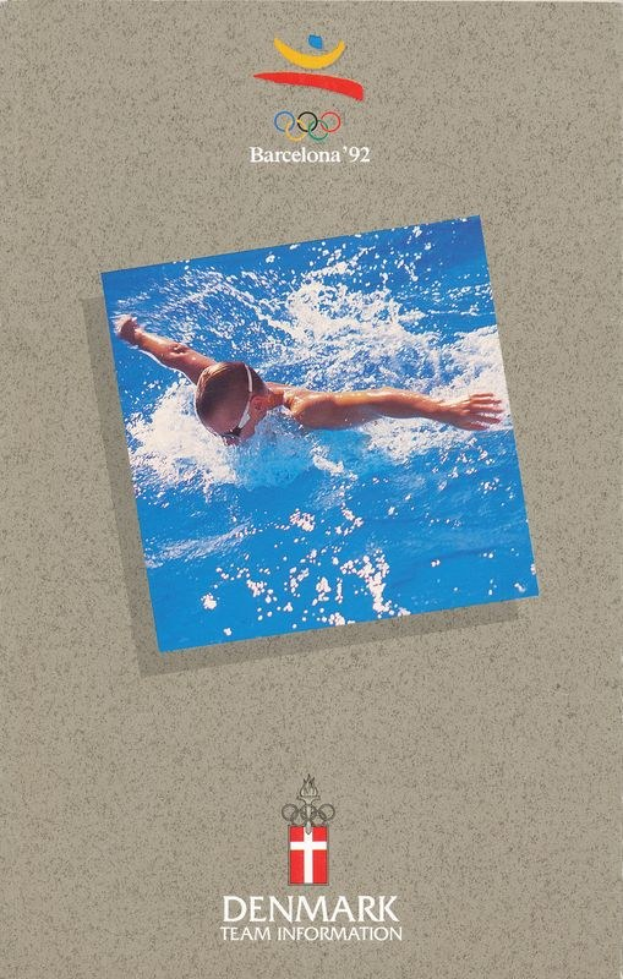 Plakat mit einem Schwimmer in einem blauen Anzug mit ausgestreckten Armen im Wasser, unter einem hellblauen Himmel mit weißen Wolken, mit dem Logo und dem Text der Olympischen Spiele 1992 in Barcelona, Dänemark.