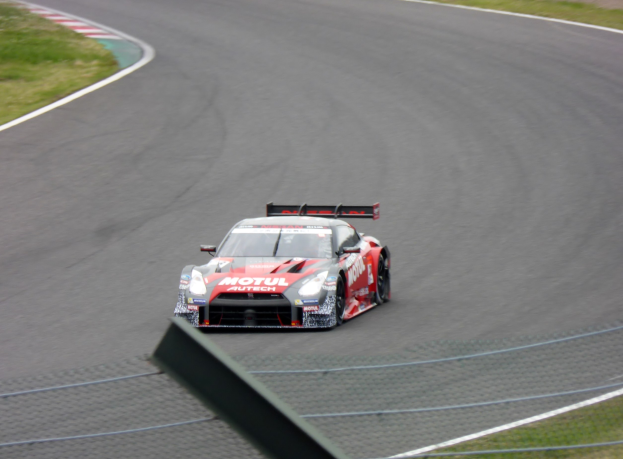 Nissan GT-R Nismo GT3 Rennauto auf der Nürburgring 24 Stunden Rennstrecke, umgeben von grünem Gras.