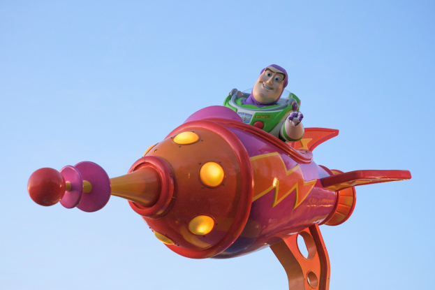 Buzz Lightyear aus Toy Story 4 fliegt in einem Spielzeugraketen an Disney's Hollywood Studios gegen einen hellblauen Himmel.