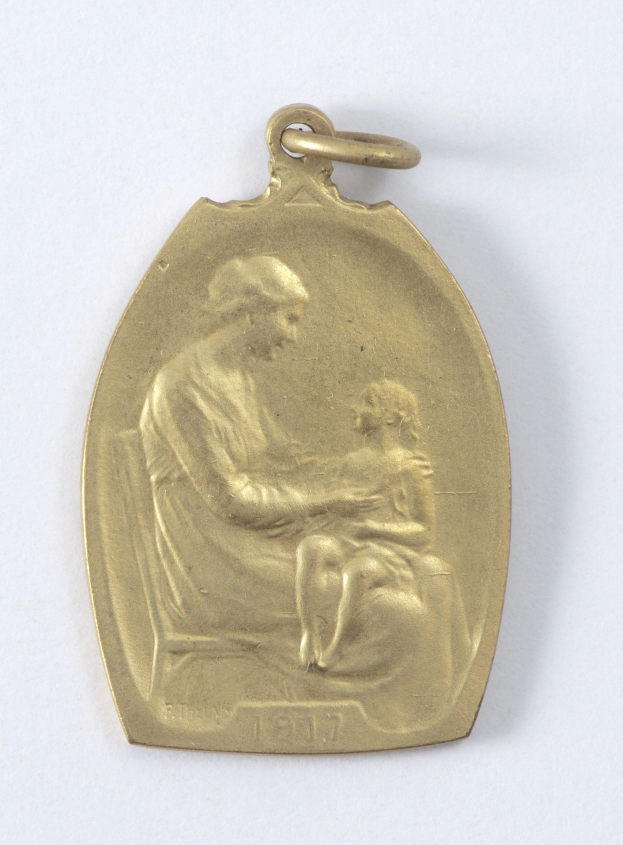 Goldmedaille mit einer Reliefdarstellung einer Frau in einem weißen Kleid mit einem Knoten im Haar, die ein Kind hält, beide sehen sich sanft an, mit der Inschrift "Mutter und Kind."